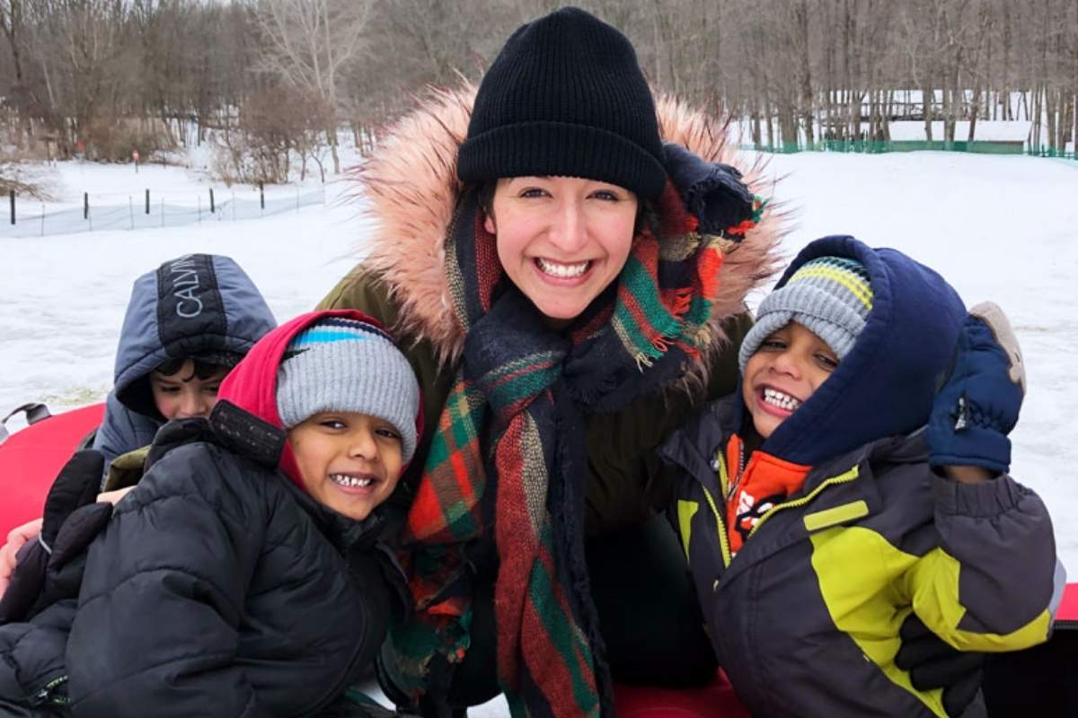 Mom and kids sledding in snow from Lansing Family fun