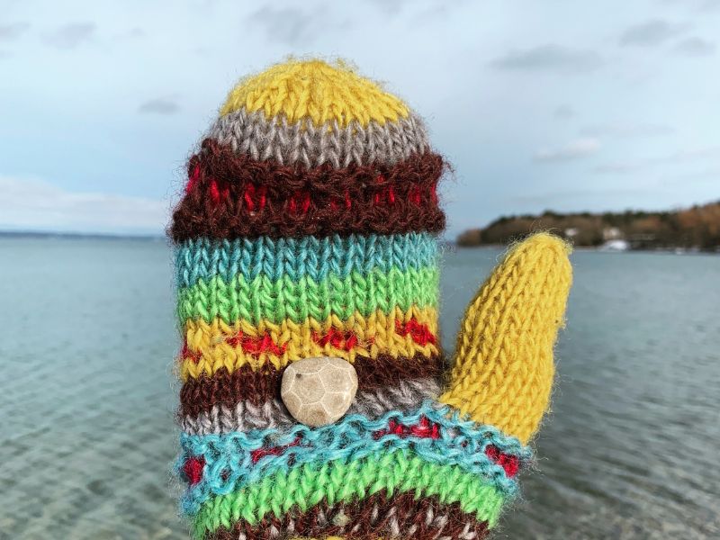 Knit Mitten holding a little Petoskey Stone found at  Bryant Park Beach in Traverse City, MI