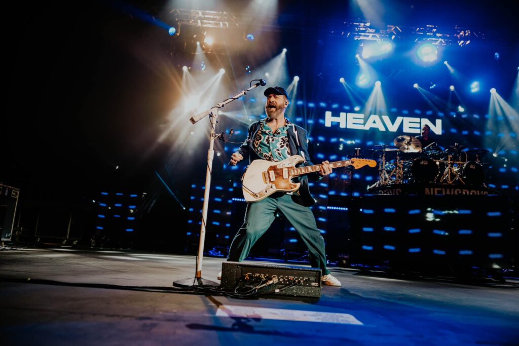 Unity Christian Music Festival Muskegon singer on stage with heaven sign fb