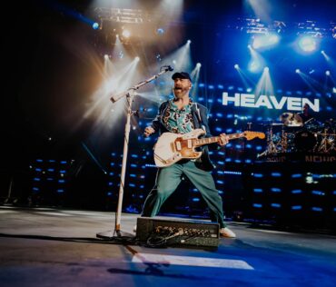 Unity Christian Music Festival Muskegon singer on stage with heaven sign fb