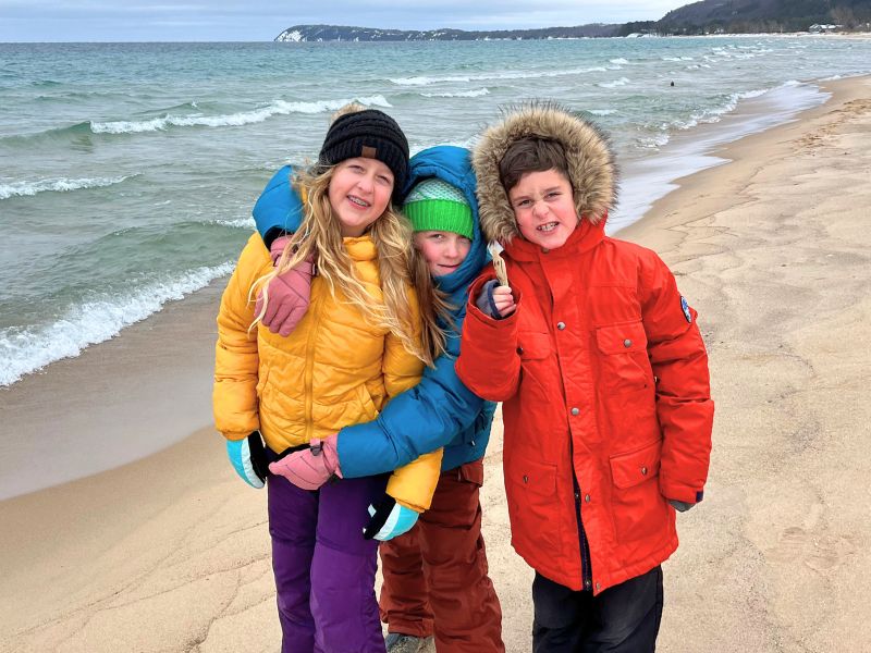 kids in winter gear on beach